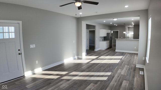 unfurnished living room featuring dark hardwood / wood-style flooring and ceiling fan