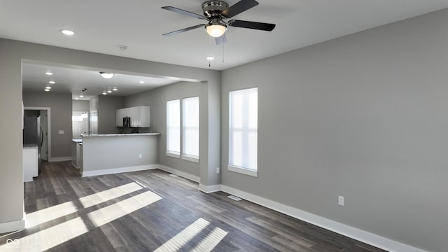 unfurnished living room with ceiling fan and dark hardwood / wood-style flooring