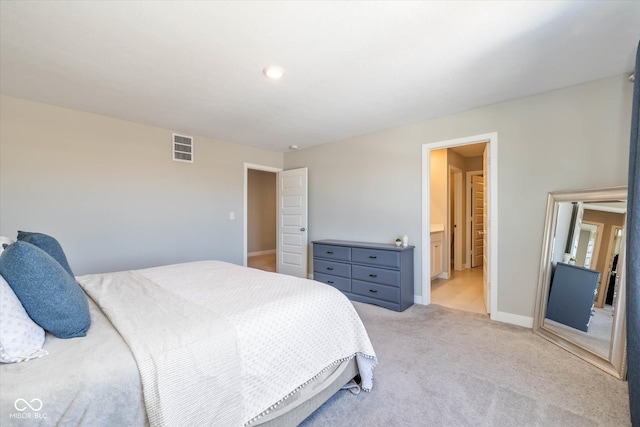 carpeted bedroom featuring ensuite bath