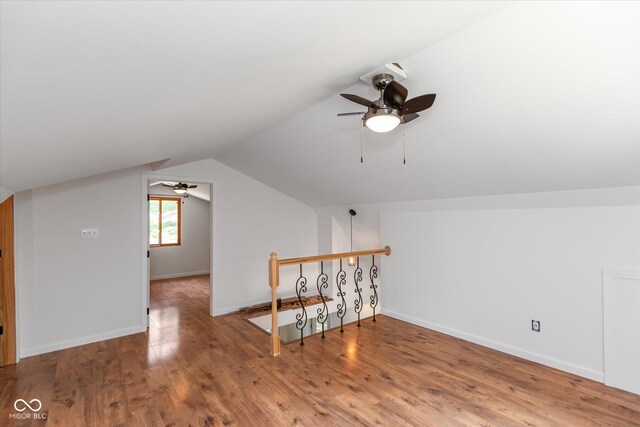 additional living space with lofted ceiling, ceiling fan, baseboards, and wood finished floors