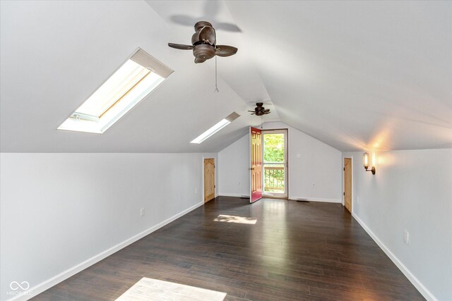 additional living space with ceiling fan, dark wood-type flooring, and vaulted ceiling with skylight