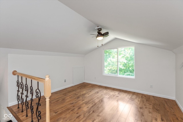 additional living space featuring a ceiling fan, vaulted ceiling, baseboards, and wood finished floors