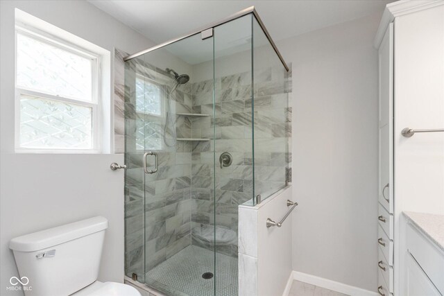 bathroom featuring vanity, a shower with shower door, and toilet