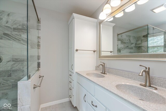 bathroom featuring tiled shower and vanity