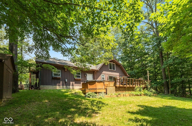 rear view of house featuring a lawn and a wooden deck