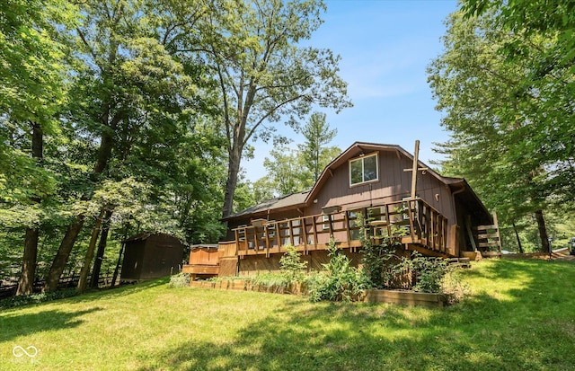 rear view of property featuring a lawn and a wooden deck