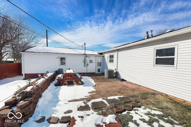 snow covered back of property with central AC unit