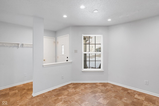 unfurnished room with a textured ceiling