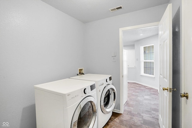 laundry area featuring a textured ceiling and washer and clothes dryer