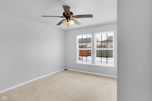 carpeted empty room with ceiling fan and a textured ceiling