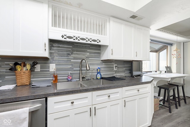 kitchen with sink, white cabinetry, tasteful backsplash, hanging light fixtures, and stainless steel dishwasher