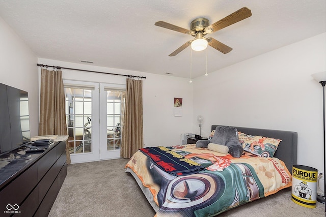 carpeted bedroom featuring french doors, ceiling fan, and a textured ceiling