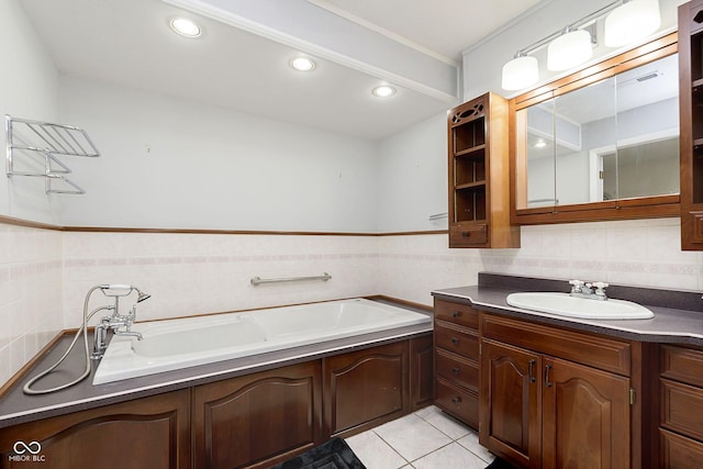 bathroom featuring a tub to relax in, tile patterned flooring, tile walls, and vanity