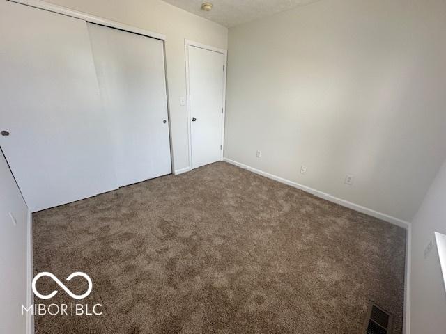 unfurnished bedroom featuring carpet floors and a closet