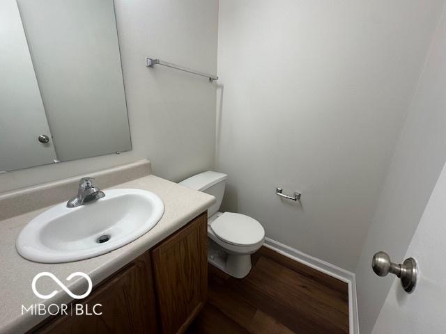 bathroom featuring vanity, toilet, and hardwood / wood-style flooring