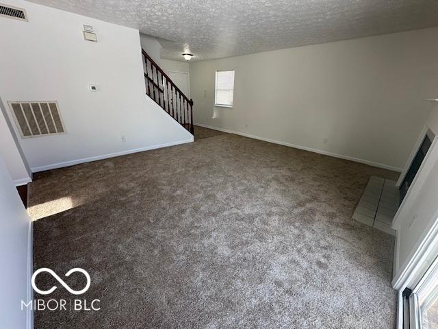 unfurnished living room with a textured ceiling and carpet