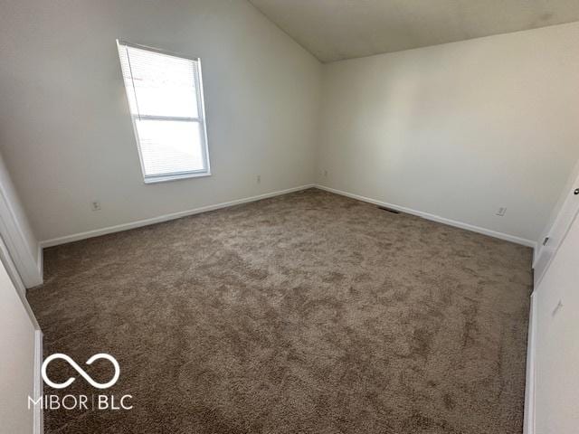 empty room with carpet and vaulted ceiling