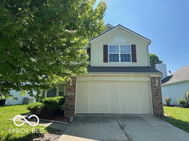 11663 Congressional Ln, Indianapolis, IN 46235 - view of front of house featuring brick siding, a garage, and concrete driveway
