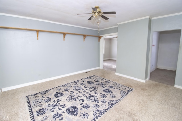 carpeted empty room with ceiling fan and ornamental molding