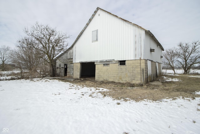 snow covered property featuring an outbuilding