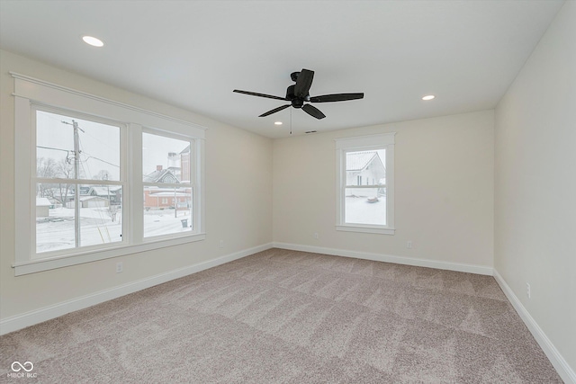 spare room featuring light colored carpet and ceiling fan