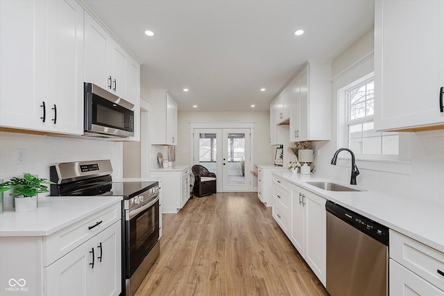 kitchen featuring sink, a wealth of natural light, stainless steel appliances, and white cabinets