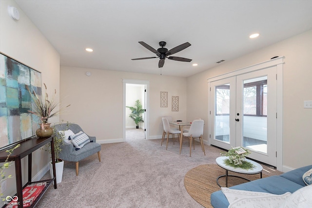 sitting room with light colored carpet, ceiling fan, and french doors