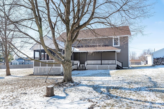 snow covered back of property with covered porch