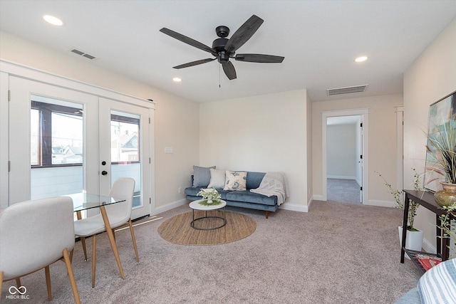 carpeted living room with ceiling fan and french doors