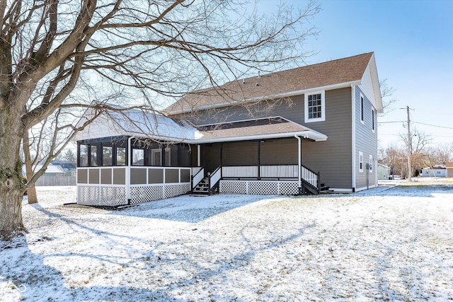 snow covered property with a sunroom