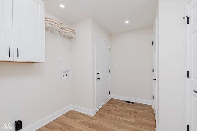 clothes washing area with washer hookup and light hardwood / wood-style floors