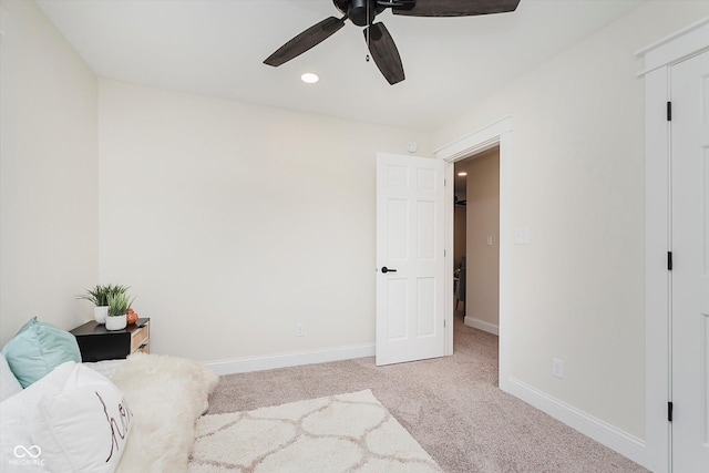 sitting room with ceiling fan and light carpet