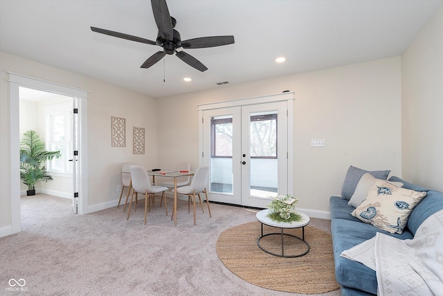 living room featuring light colored carpet, ceiling fan, and french doors