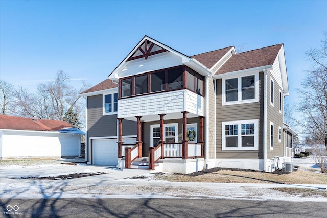 view of front of property with a garage, a sunroom, central air condition unit, and a porch