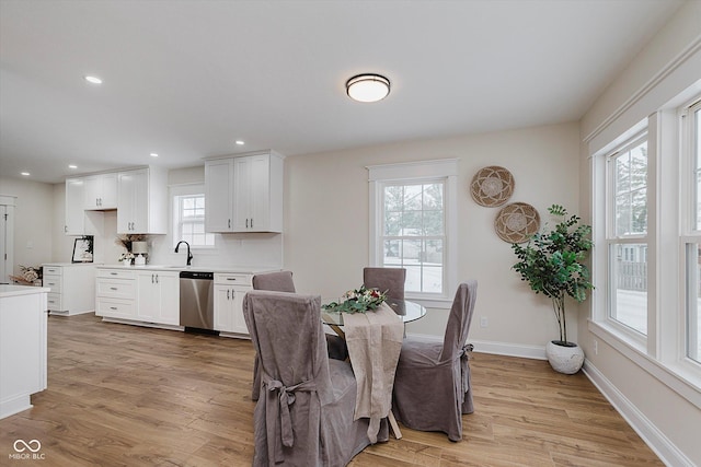 dining area with sink, light hardwood / wood-style flooring, and a healthy amount of sunlight