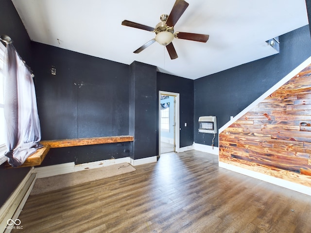 unfurnished living room with wood-type flooring, heating unit, ceiling fan, and a baseboard radiator