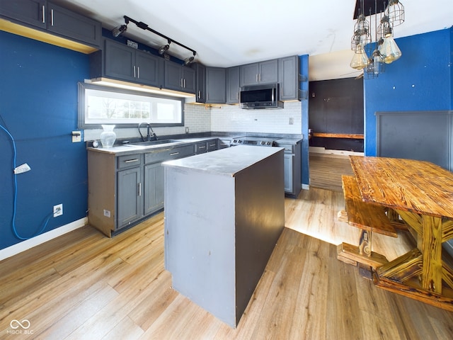 kitchen featuring pendant lighting, sink, decorative backsplash, a center island, and light hardwood / wood-style floors