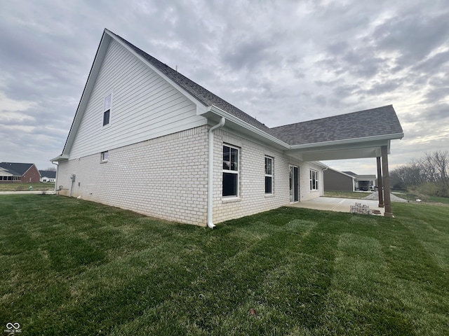 view of side of home with a yard and a patio