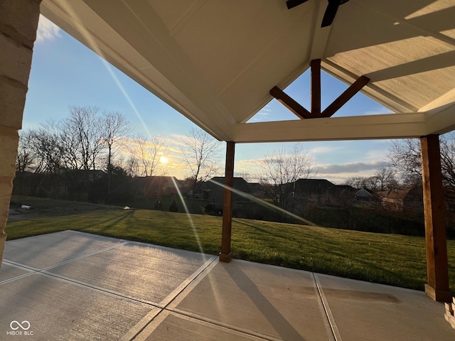 patio terrace at dusk featuring a yard and ceiling fan