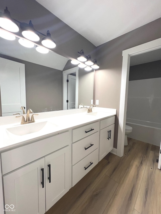 bathroom with vanity, toilet, and wood-type flooring