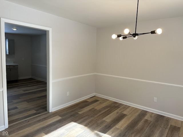 unfurnished dining area with dark hardwood / wood-style floors and a chandelier