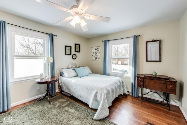 bedroom with multiple windows, hardwood / wood-style flooring, and ceiling fan