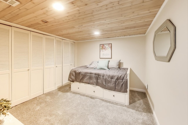 bedroom featuring light colored carpet, wooden ceiling, and a closet