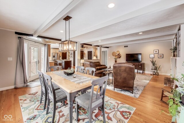 dining space featuring light hardwood / wood-style flooring and beamed ceiling