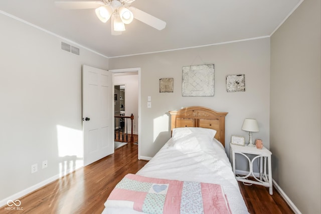 bedroom with dark wood-type flooring, ceiling fan, and crown molding