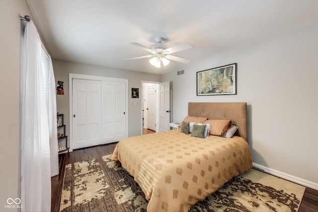 bedroom with a closet, dark hardwood / wood-style floors, and ceiling fan