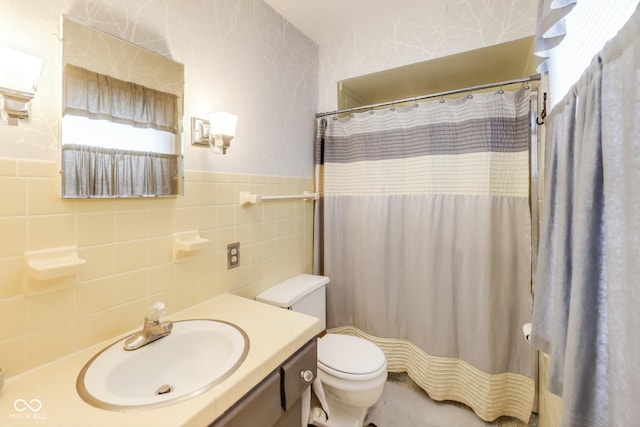 bathroom with a shower with curtain, vanity, tile walls, and toilet