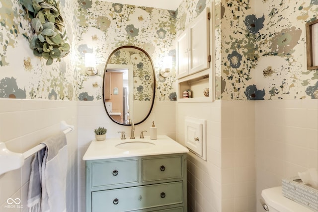 bathroom with vanity, tile walls, and toilet