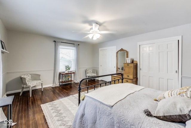 bedroom featuring multiple closets, dark wood-type flooring, and ceiling fan