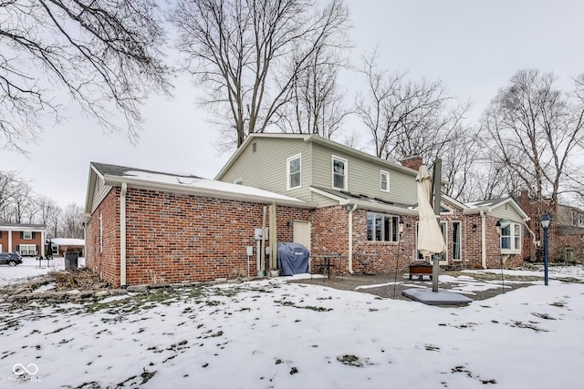 view of snow covered back of property